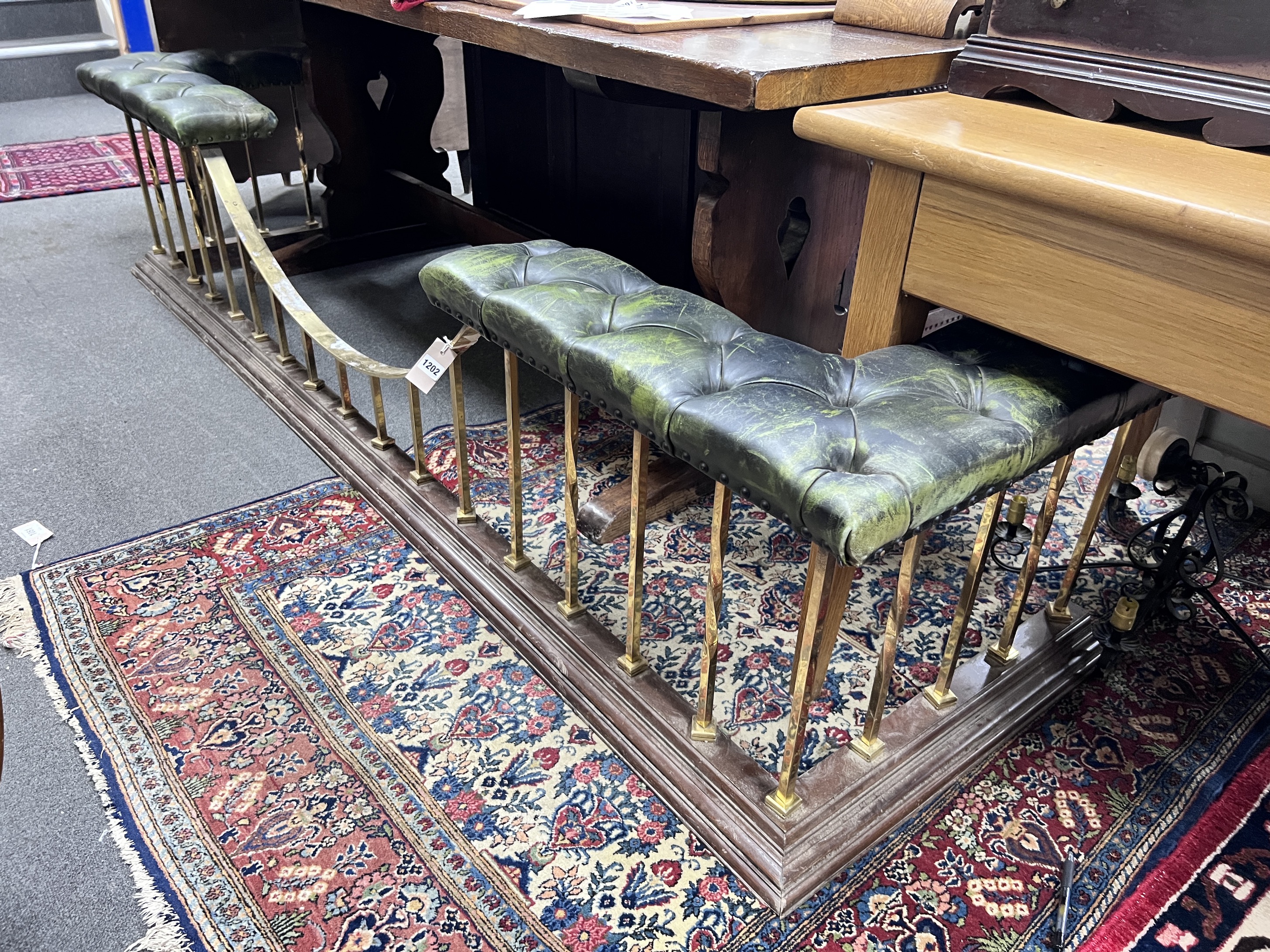 An Edwardian style brass and hardwood club fender, with simulated buttoned leather top, width 235cm, height 52cm